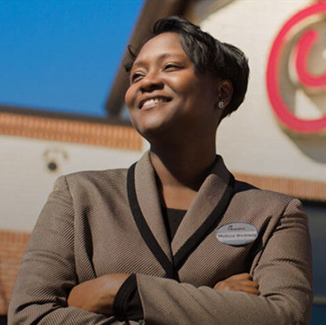 Headshot of woman proudly standing outside of a Chick-fil-A restaurant