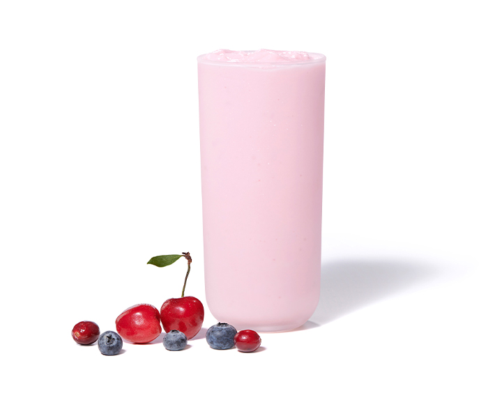 Cherry Berry Frosted Lemonade on a white background with cherries, blueberries and cranberries