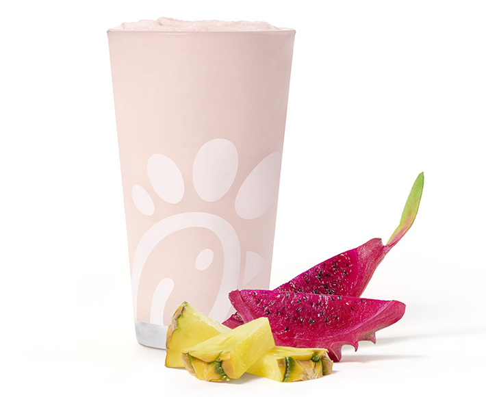 A glass of a Pineapple Dragonfruit Frosted Lemonade on a white background