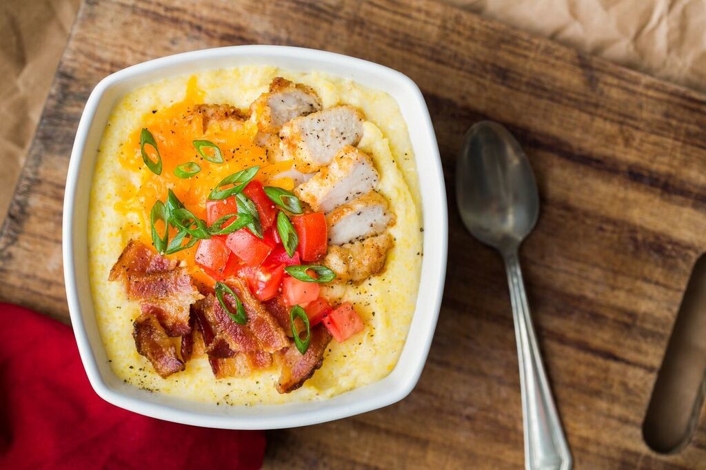 Holiday breakfast bowl of grits topped with grilled chicken, bacon and cheese