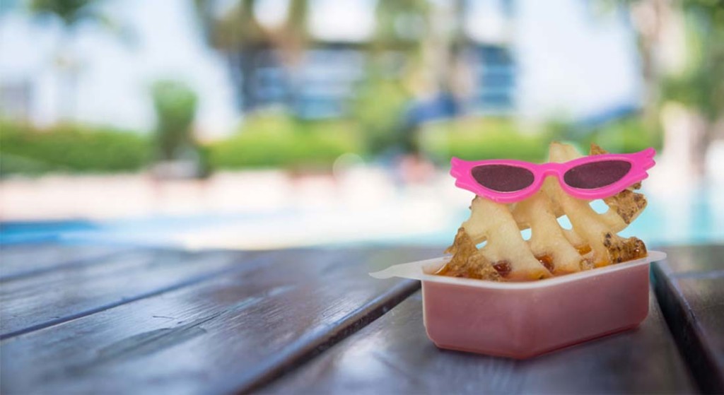 Waffle fry with sunglasses on dipped in a tub of sauce