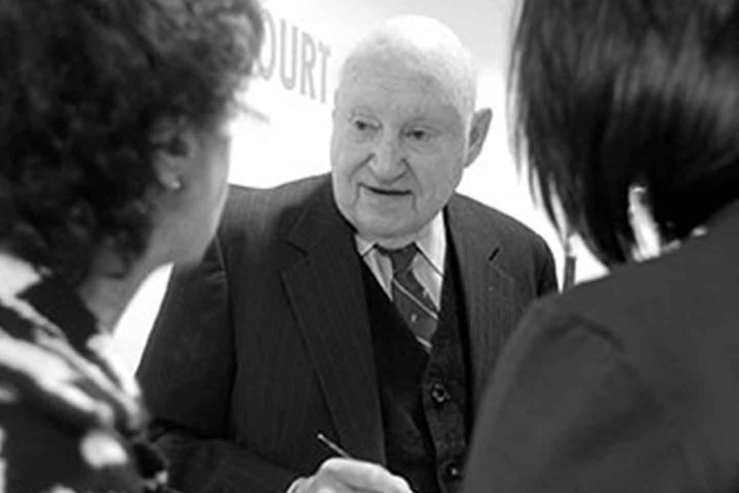 Truett Cathy speaks with two women