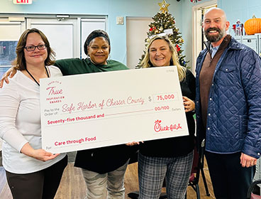People from the Safe Harbor of Chester County organization standing together smiling and holding a large check