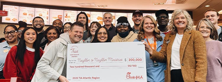 People from the Neighbor to Neighbor Ministries organization standing together smiling and holding a large check
