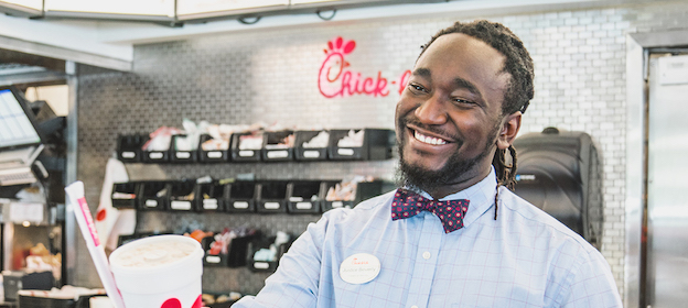 Chick-fil-A Team Leader standing behind register and smiling